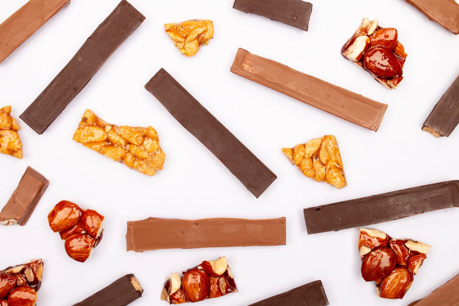 Top view of candied nuts and chocolate bars on a white background.